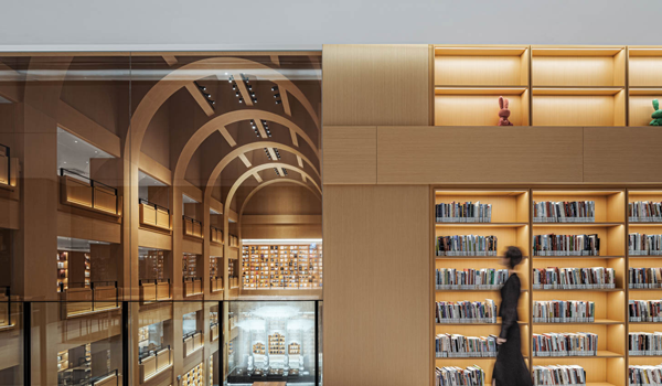 a woman walks in front of books