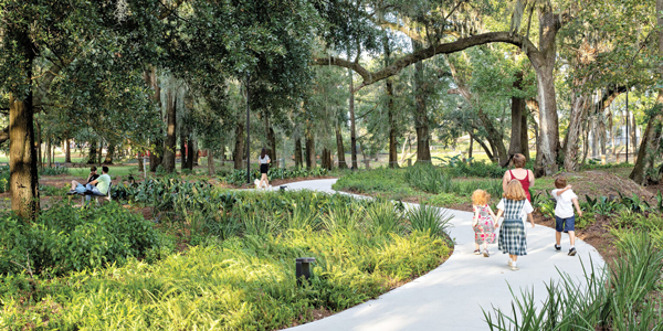 children walk through a lush green park