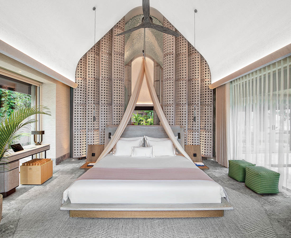 a luxurious canopy bed in a guest room of Joali Being