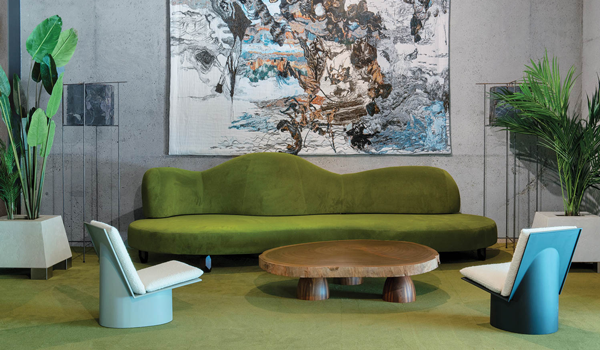 a lobby area with a tapestry behind green chairs and matching flooring