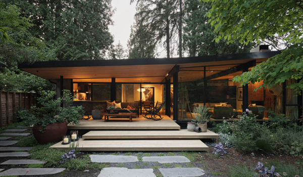 a midcentury modern home lit up at evening