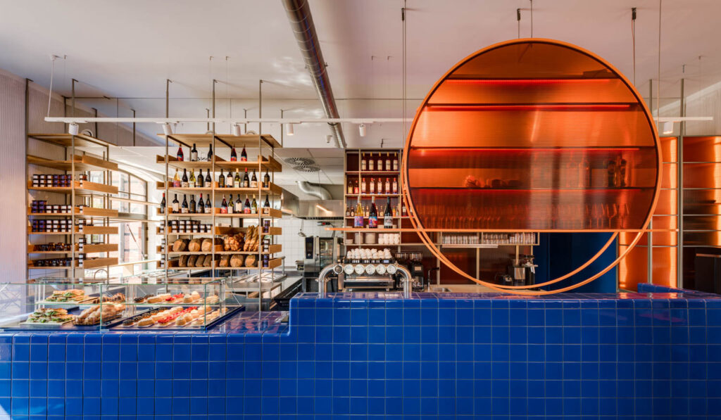 a blue tile counter with an orange circular shelf above it