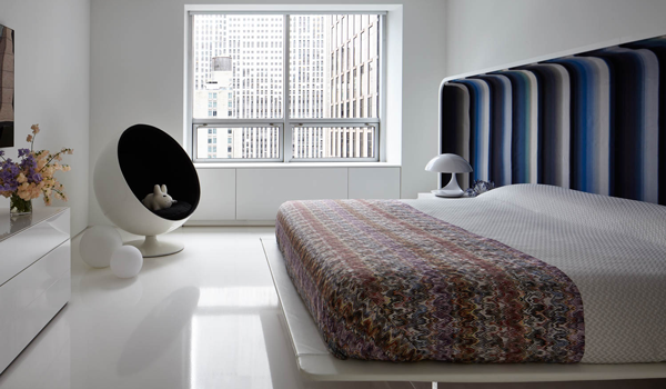 a platform bed with a curving blue headboard