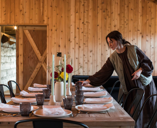 a woman sets a dining table