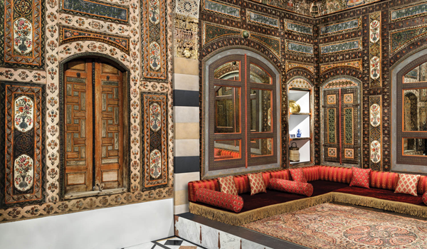 Damascus Room featuring ornate wall coverings and red low sofas
