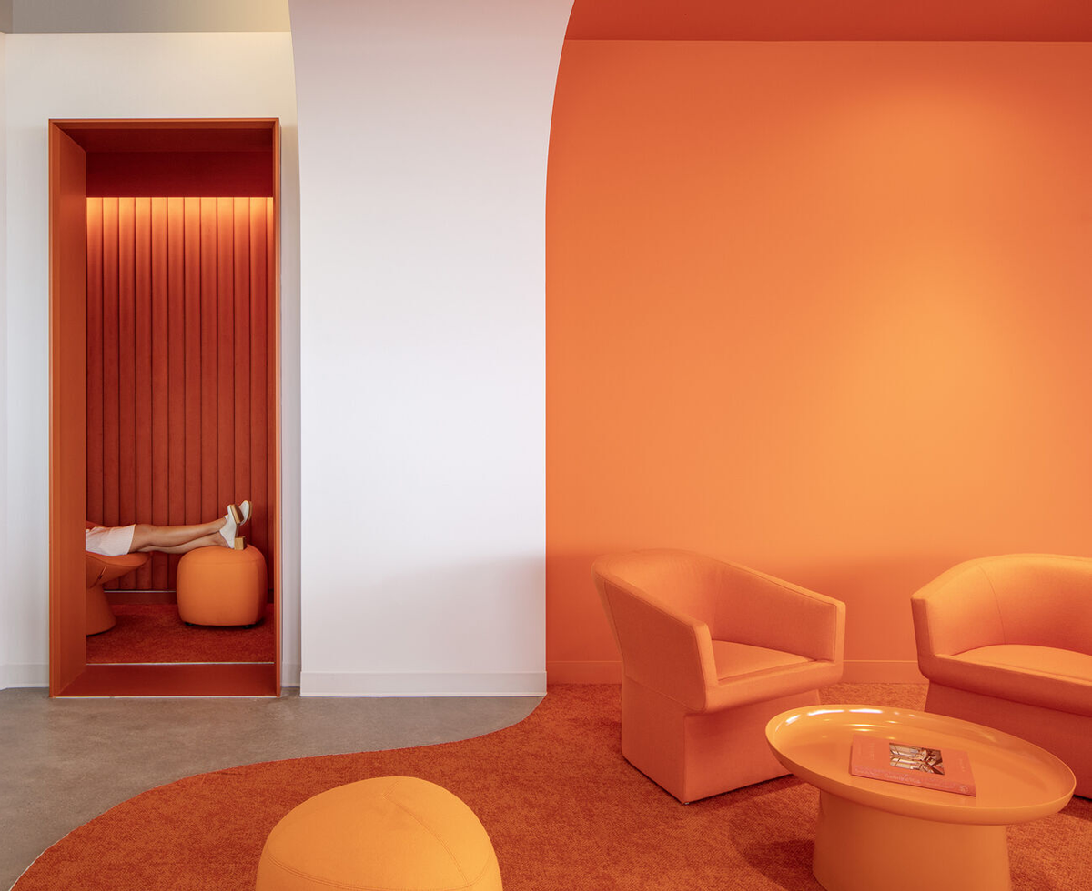an office with bright orange walls and furnishings
