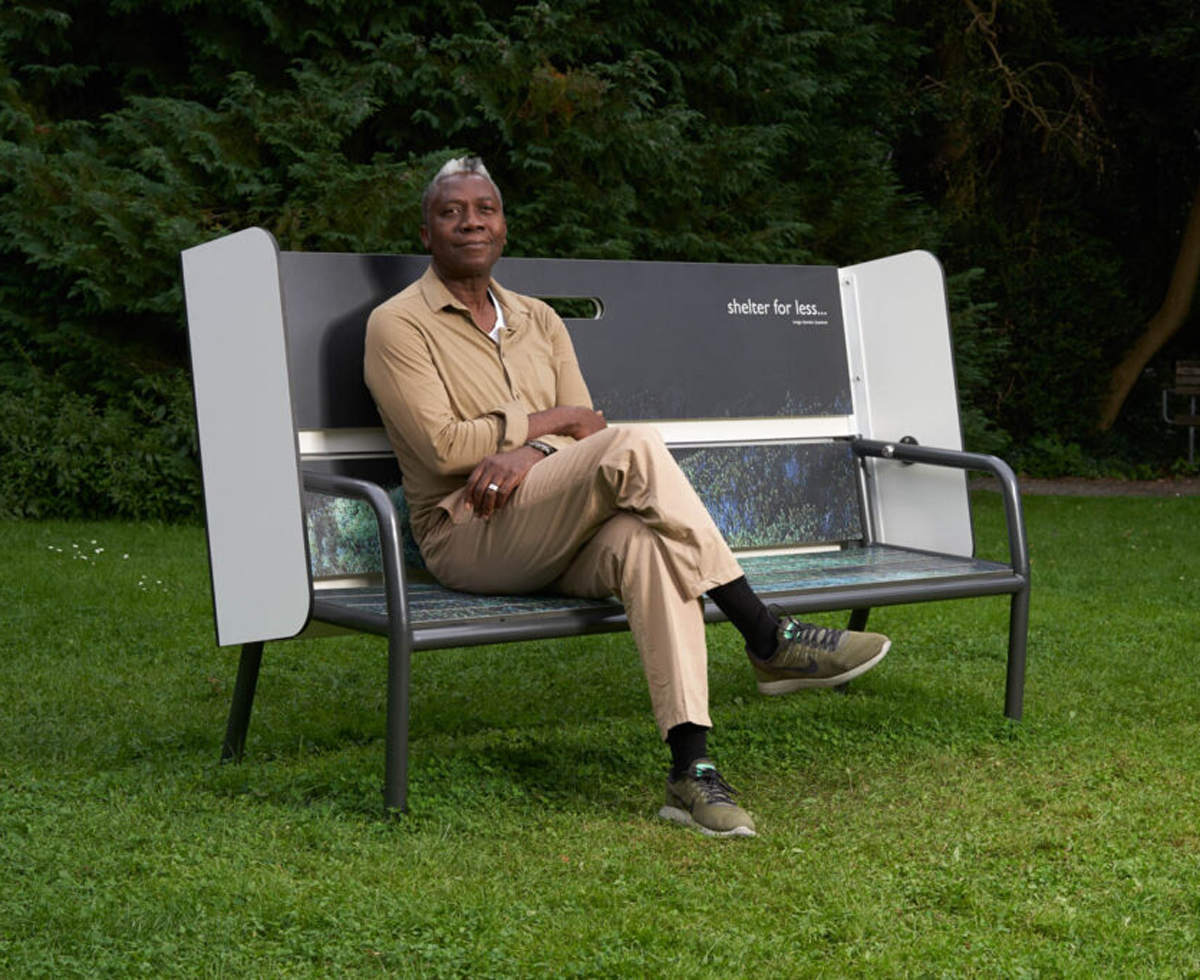 designer Charles O. Job sitting on a bench he created