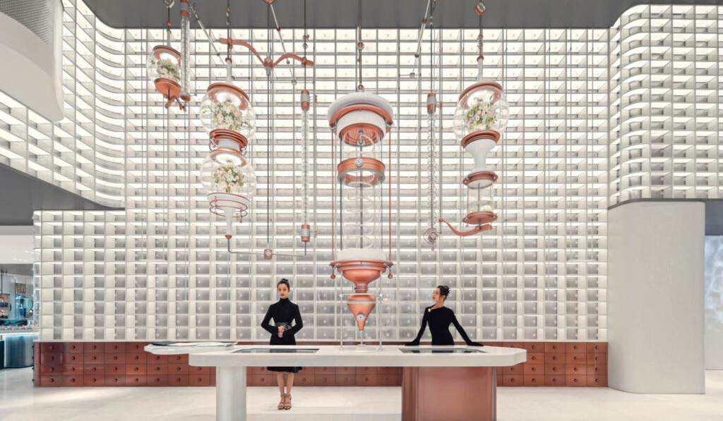 two people in black behind a counter with a ceiling installation above