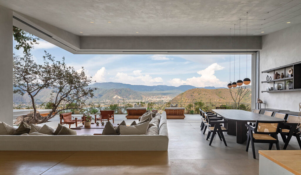 a cream sectional on an open-air living room with cliffside views
