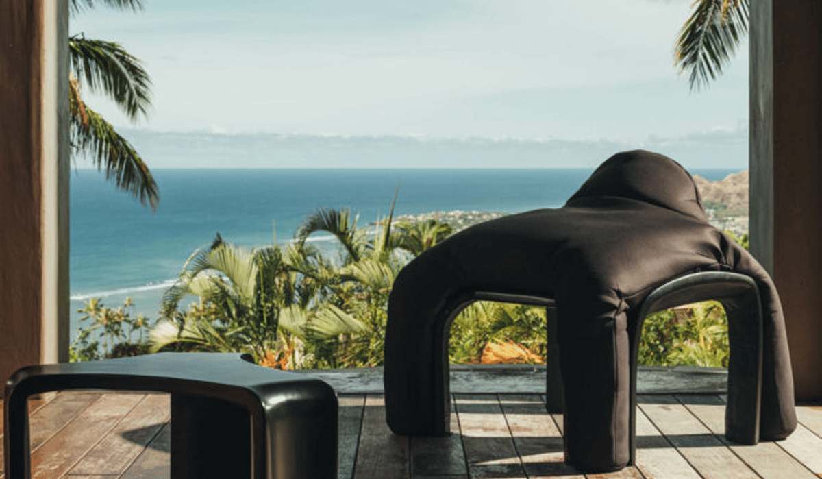 a black plush chair and stool on a patio near the beach