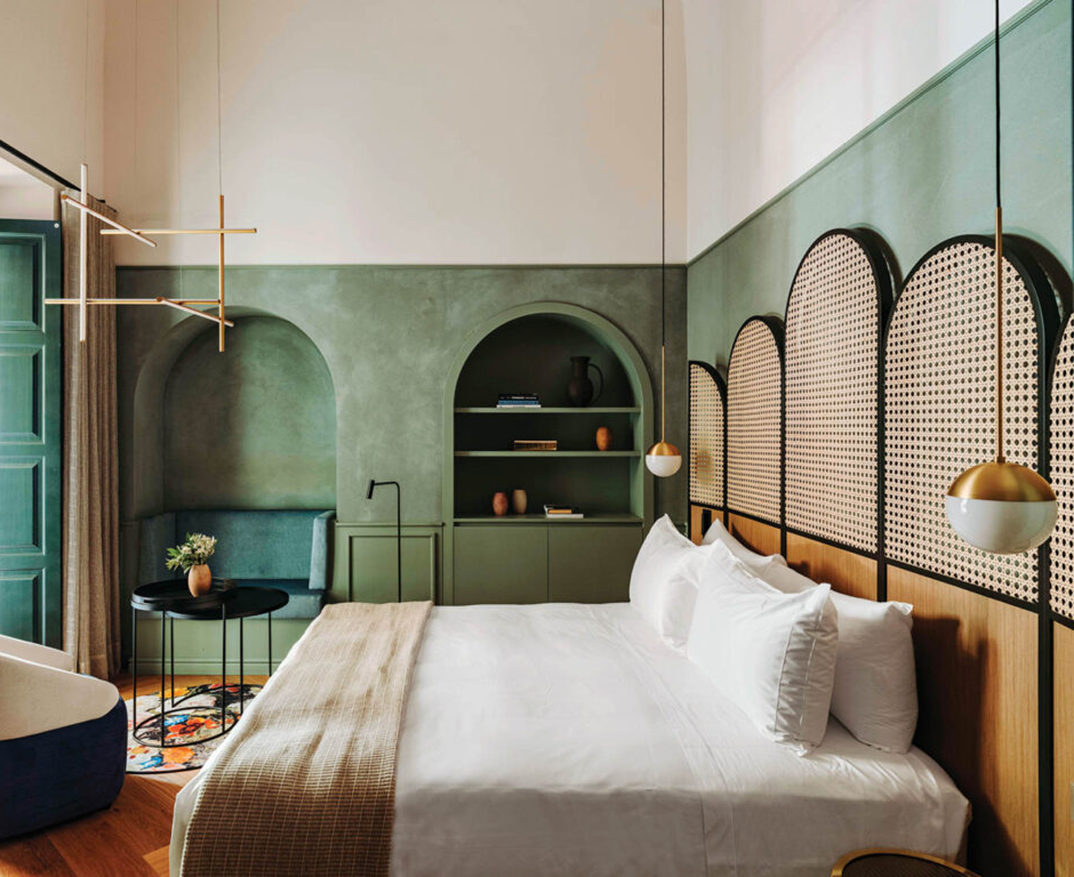 bedroom with sage green walls and bed with arched dividers