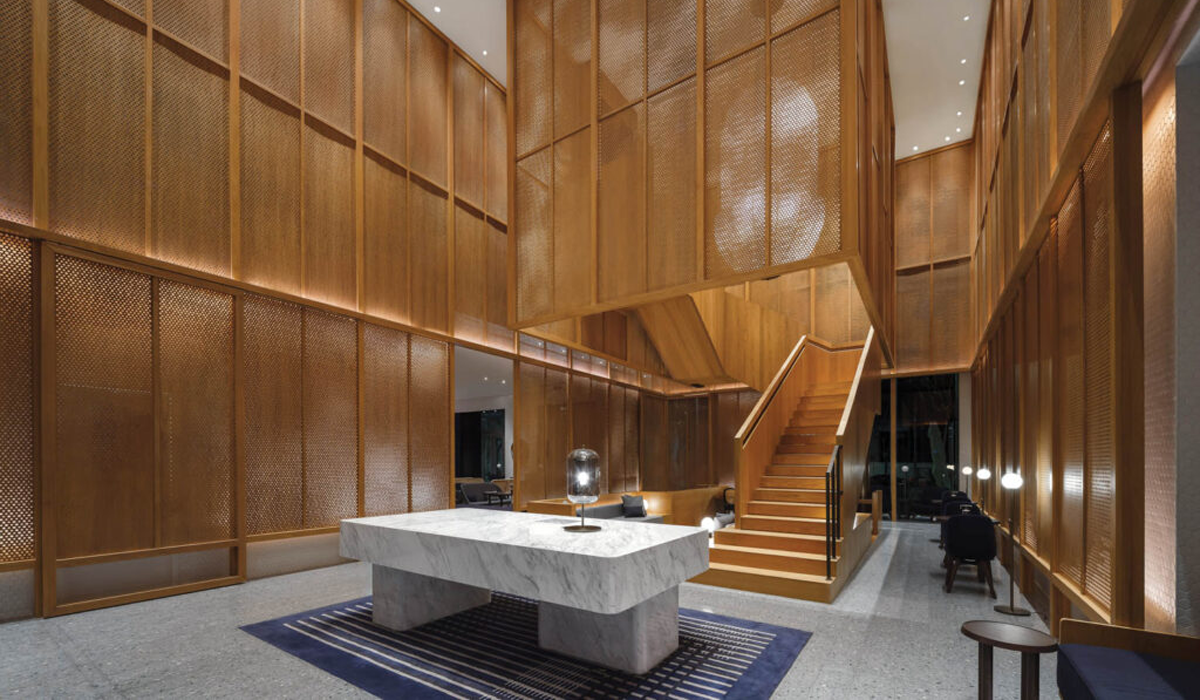 hotel lobby with large floor-to-ceiling oak screens, marbled table and glass lamps