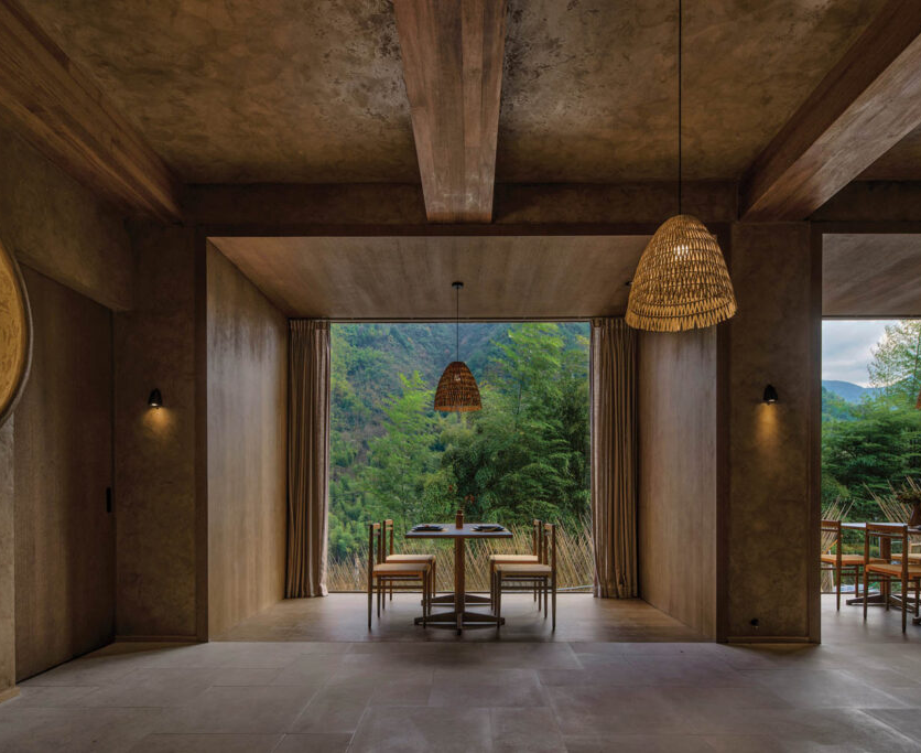 open dining space with moody palette and hanging pendants