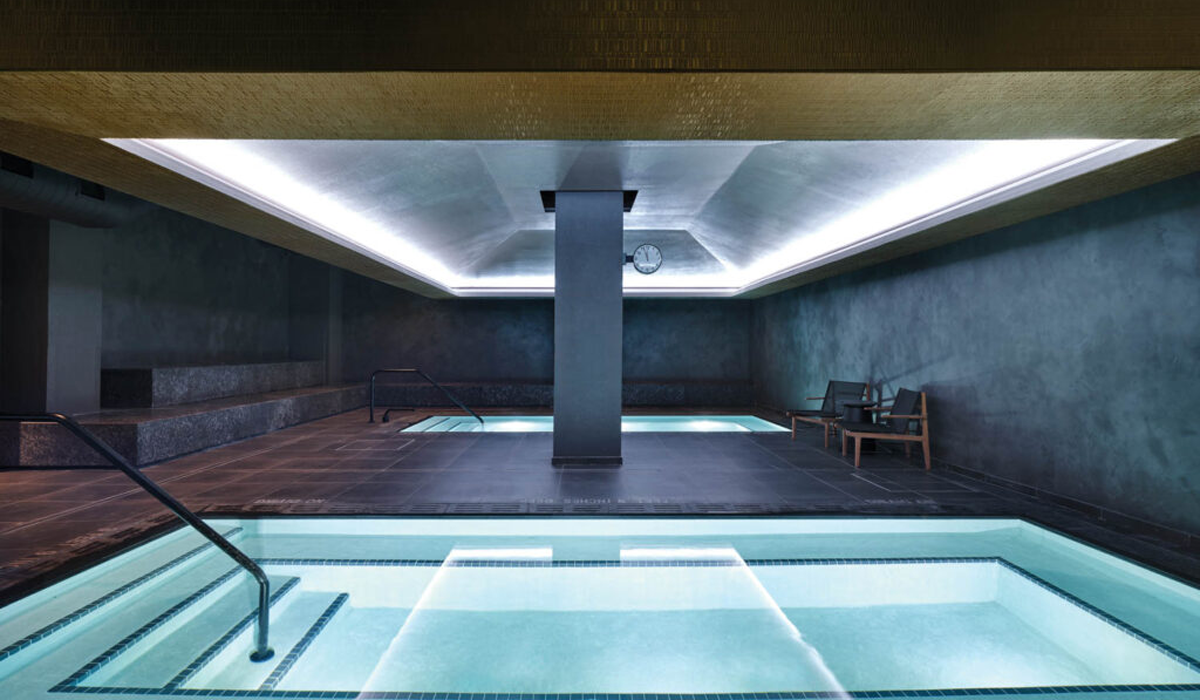 large swimming pools anchored by moody lighting and dark paneled walls