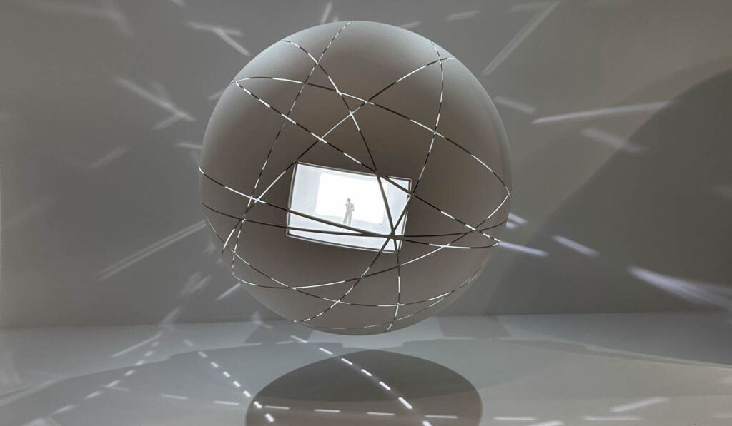 large grey orb with person inside