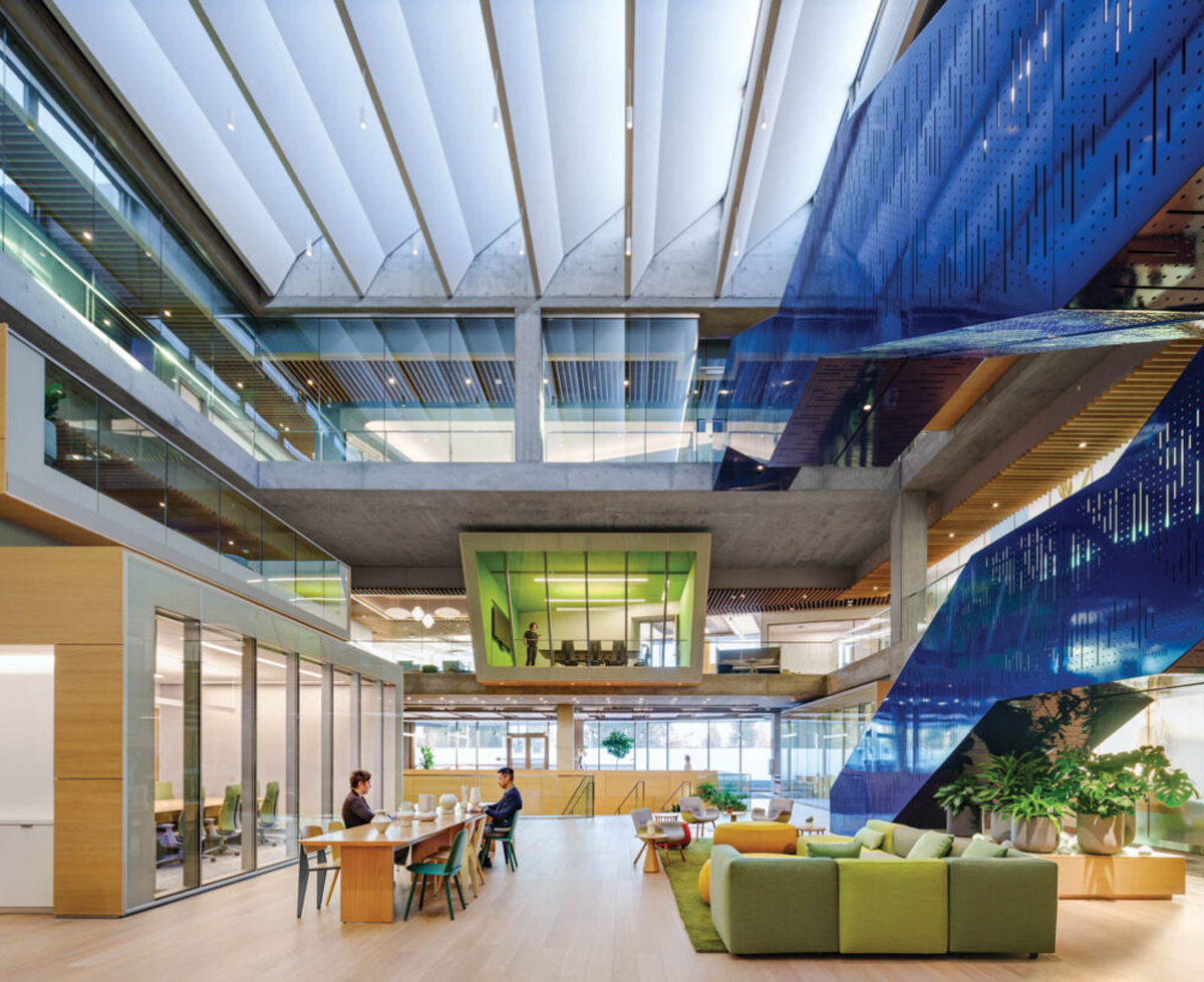 office space with blue stairs and green couches and windows
