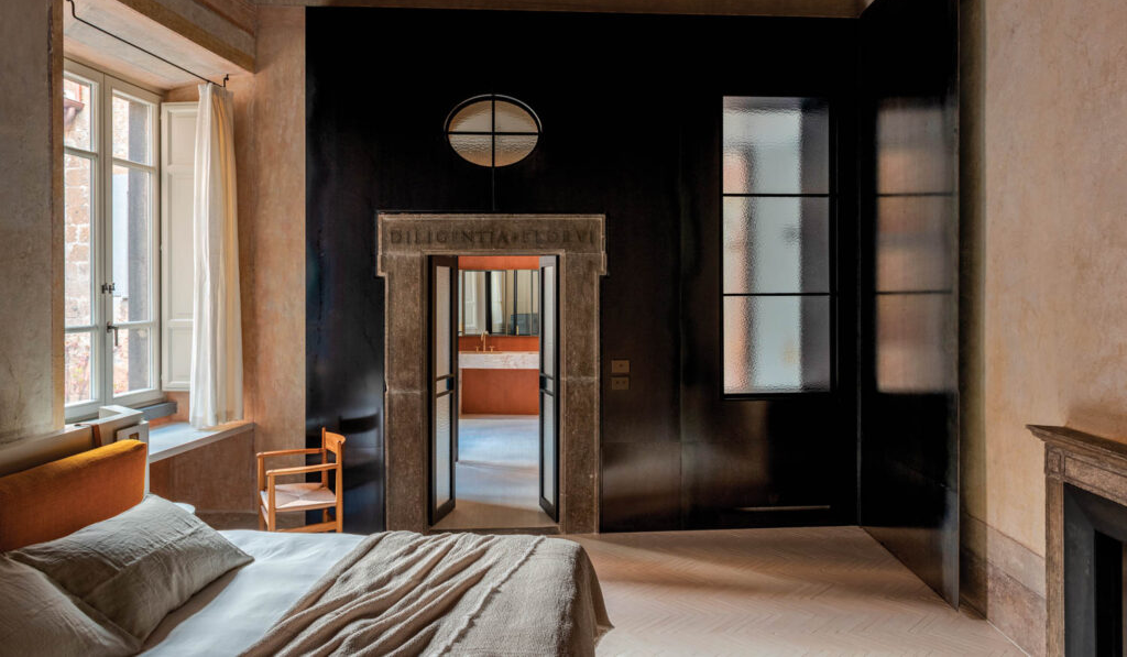 bedroom with dark blue walls and tan flooring