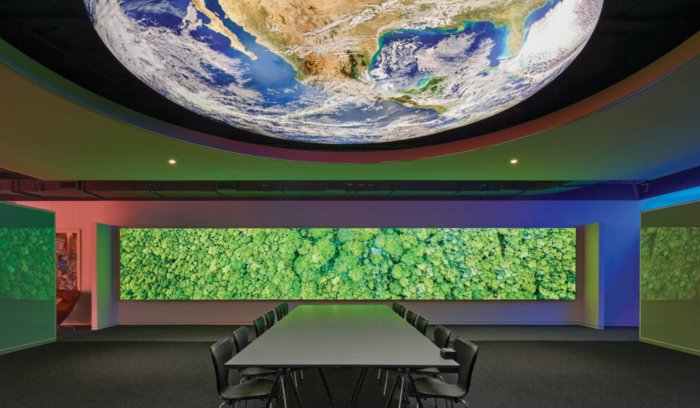 conference room with a bright green screen and digital view of a globe