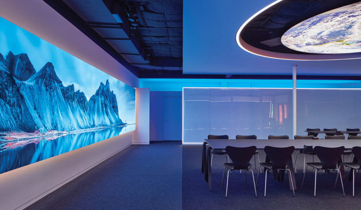 conference room with surrounding blue lights and LED screens with scenery