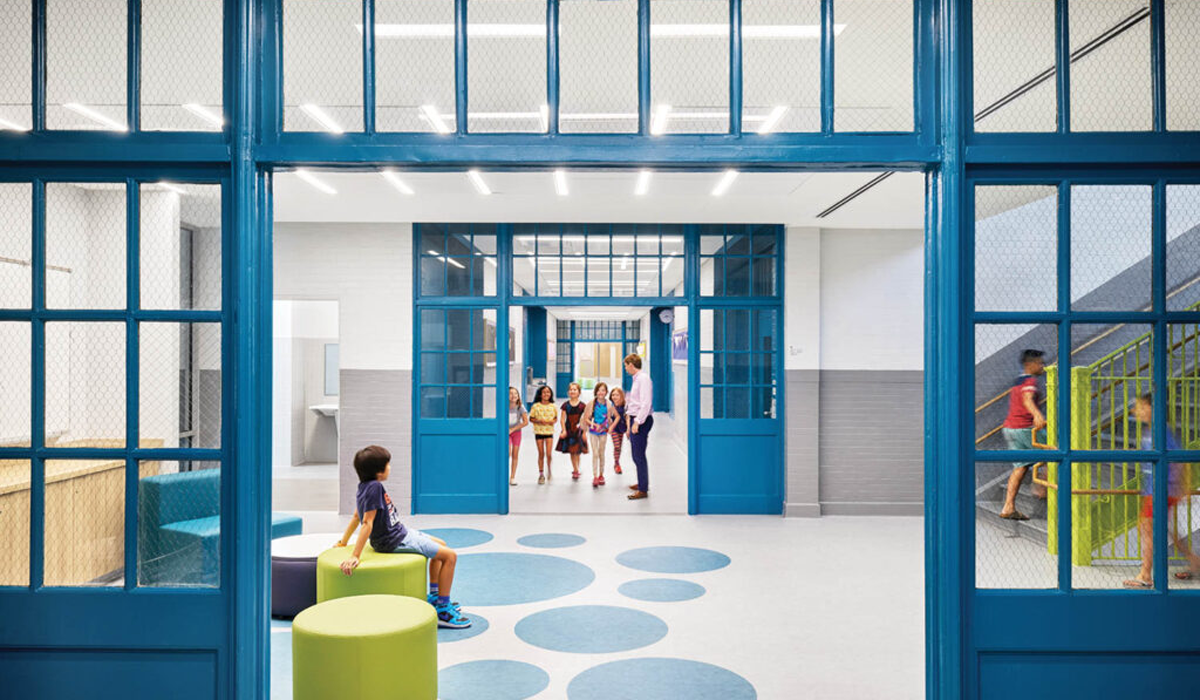 hallway of a school with dark blue entryways and multicolored seating