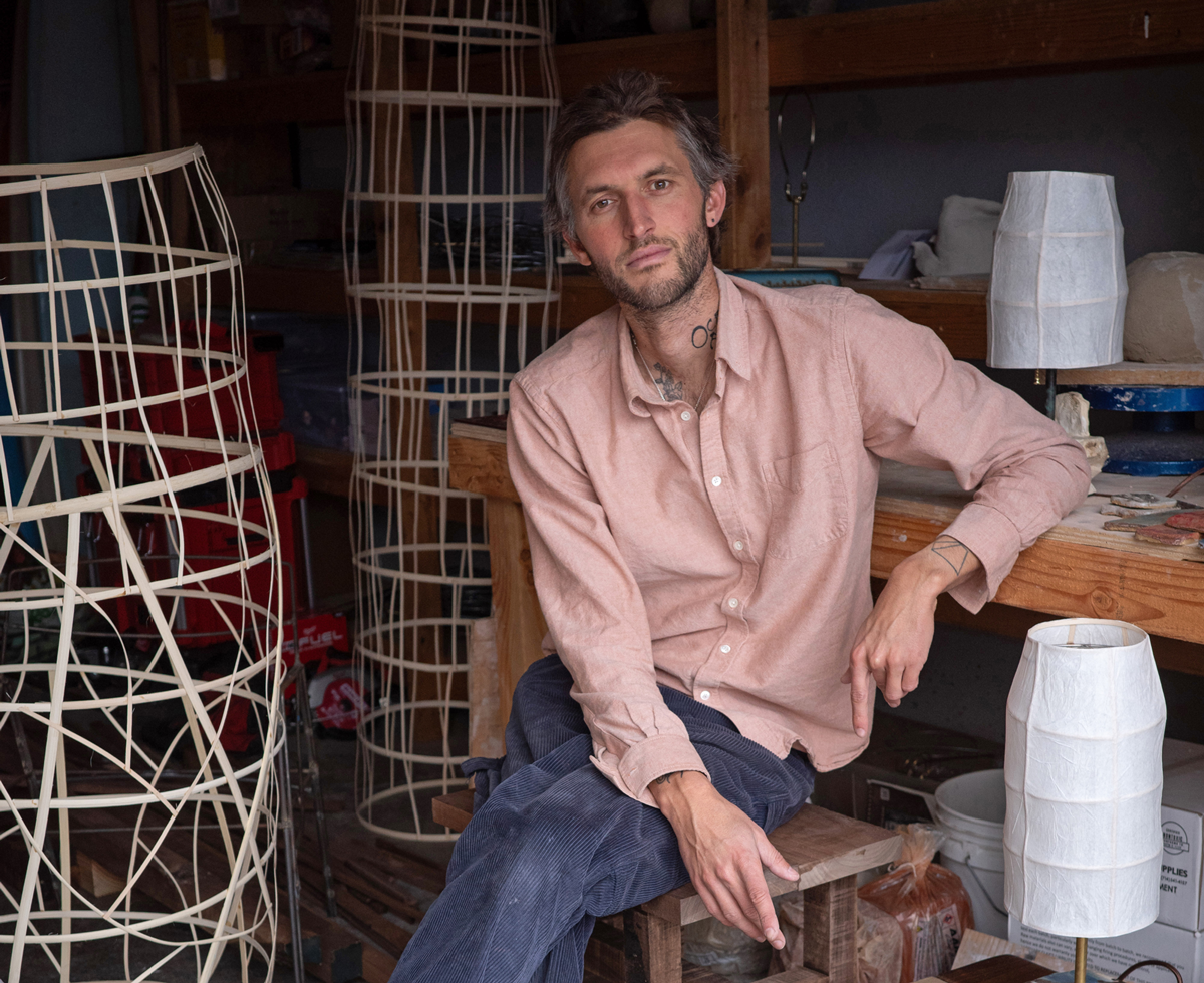 Bennet Schlesinger posing next to his lighting pieces