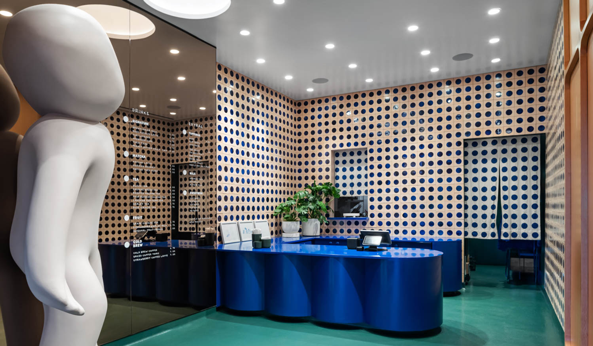 boba shop front with dotted walls, curvy desks and a large white statue