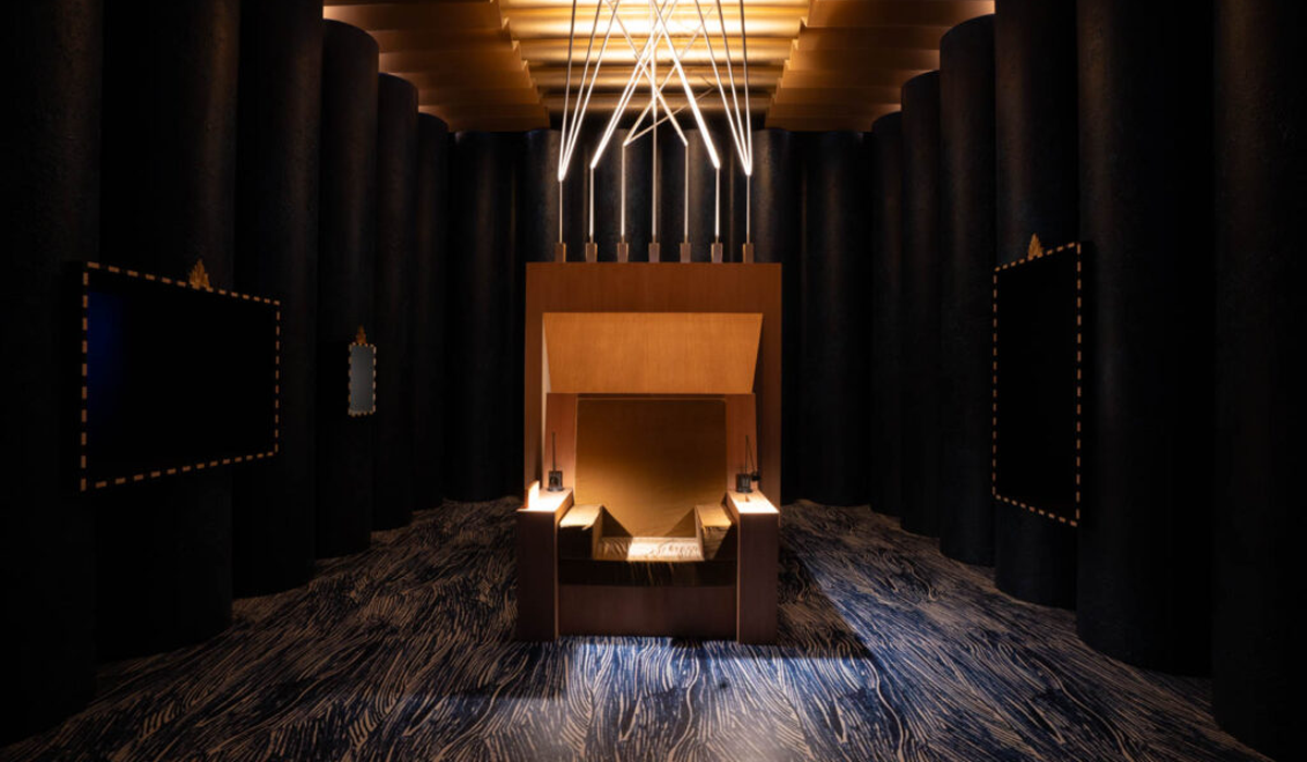 dark room with brown box connected to unique chandelier on ceiling