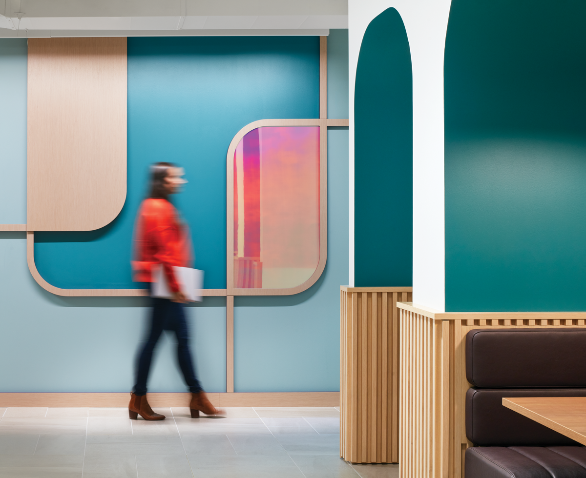 a woman walks through an office with teal walls