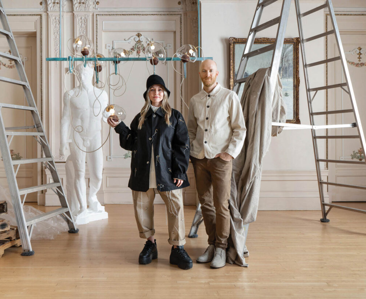 two people standing in room with orb lights and statue in background