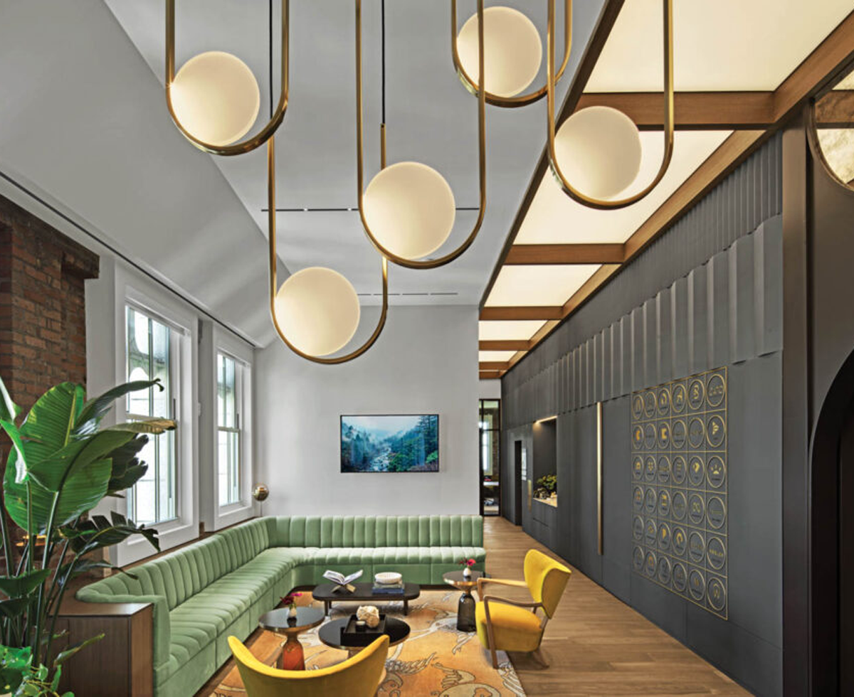 office lounge with pastel green couch, orb lamps and black wall