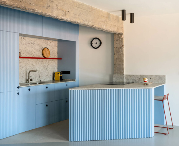 A blue kitchen with a blue island complete with a sink