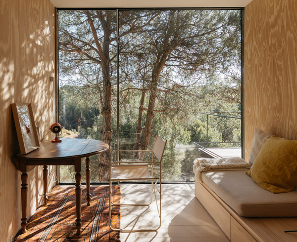 The living room looks out to the patio with trees beyond