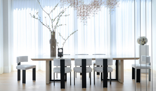 a dining table below a detailed chandelier