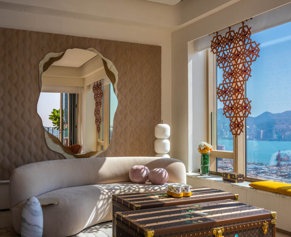 a curvy edged mirror above a sofa