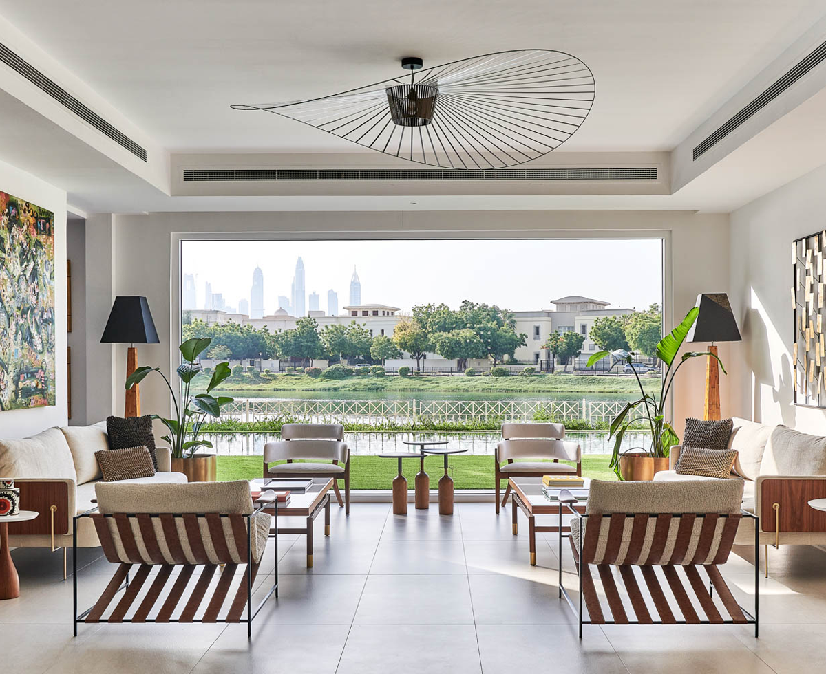 an indoor-outdoor living room with white armchairs