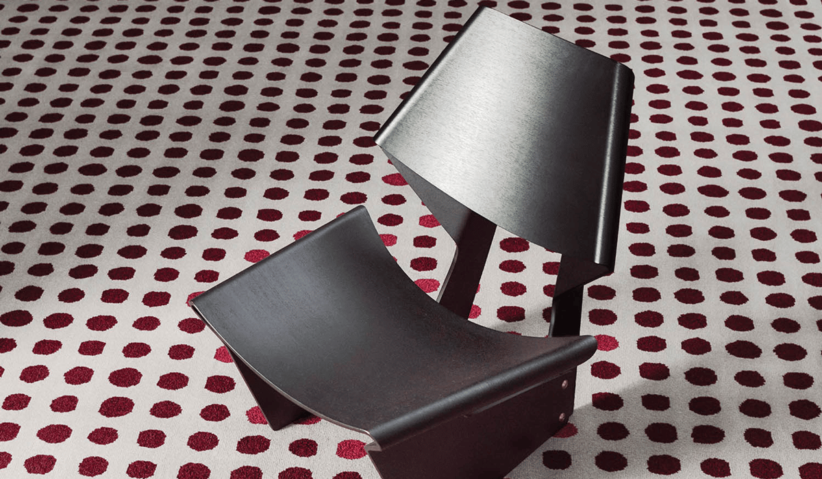 a gray chair on a red dotted carpet