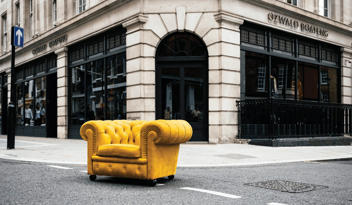 a yellow armchair on a city street