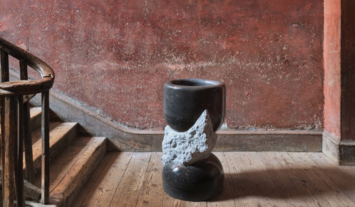obsidian black planter sitting in the stairwell against a red backdrop