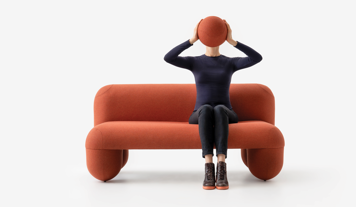 person sitting on a red couch holding a red ball