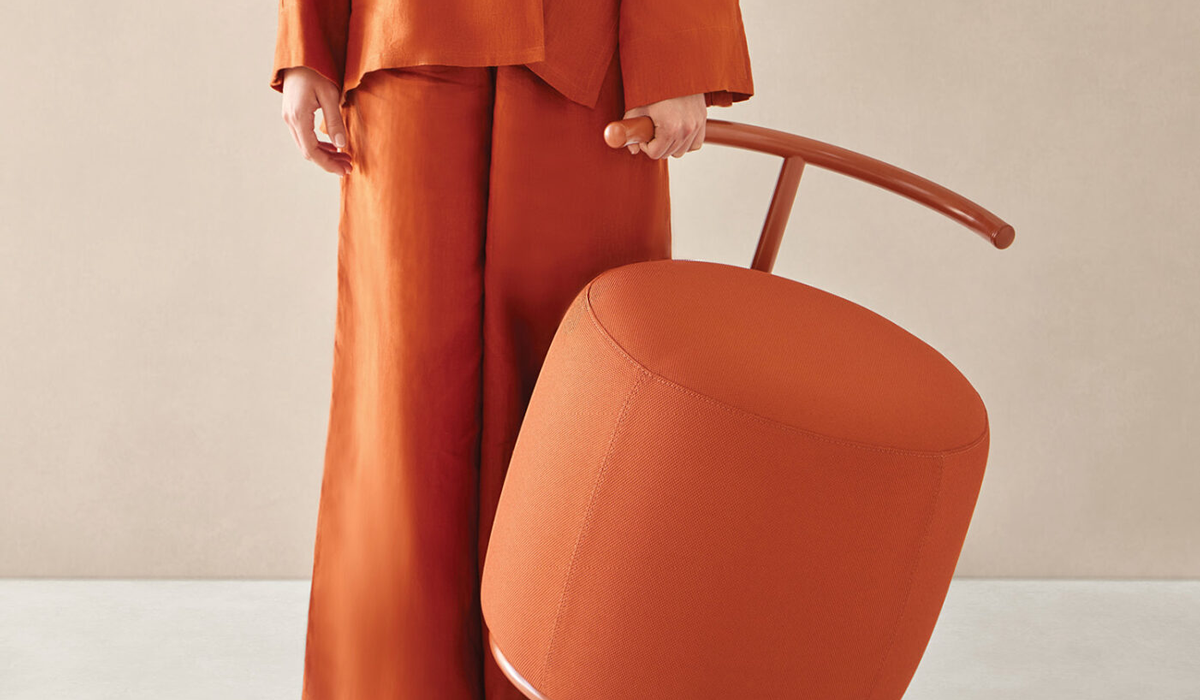 a woman holding an orange stool