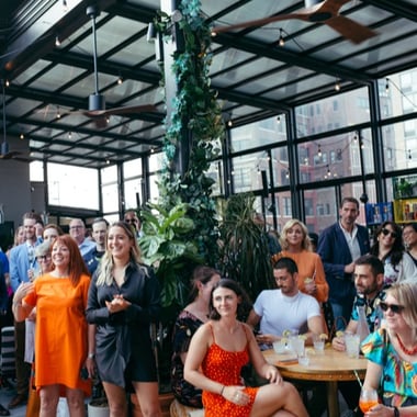 A group of people at an event watching a speaker in a modern space